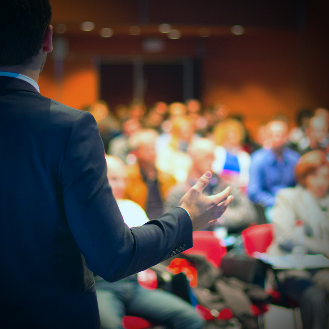 Stock photograph of speaker in front of a crowd